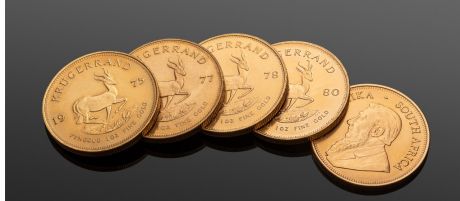 Fünf Goldmünzen Krügerrand auf schwarzem Hintergrund